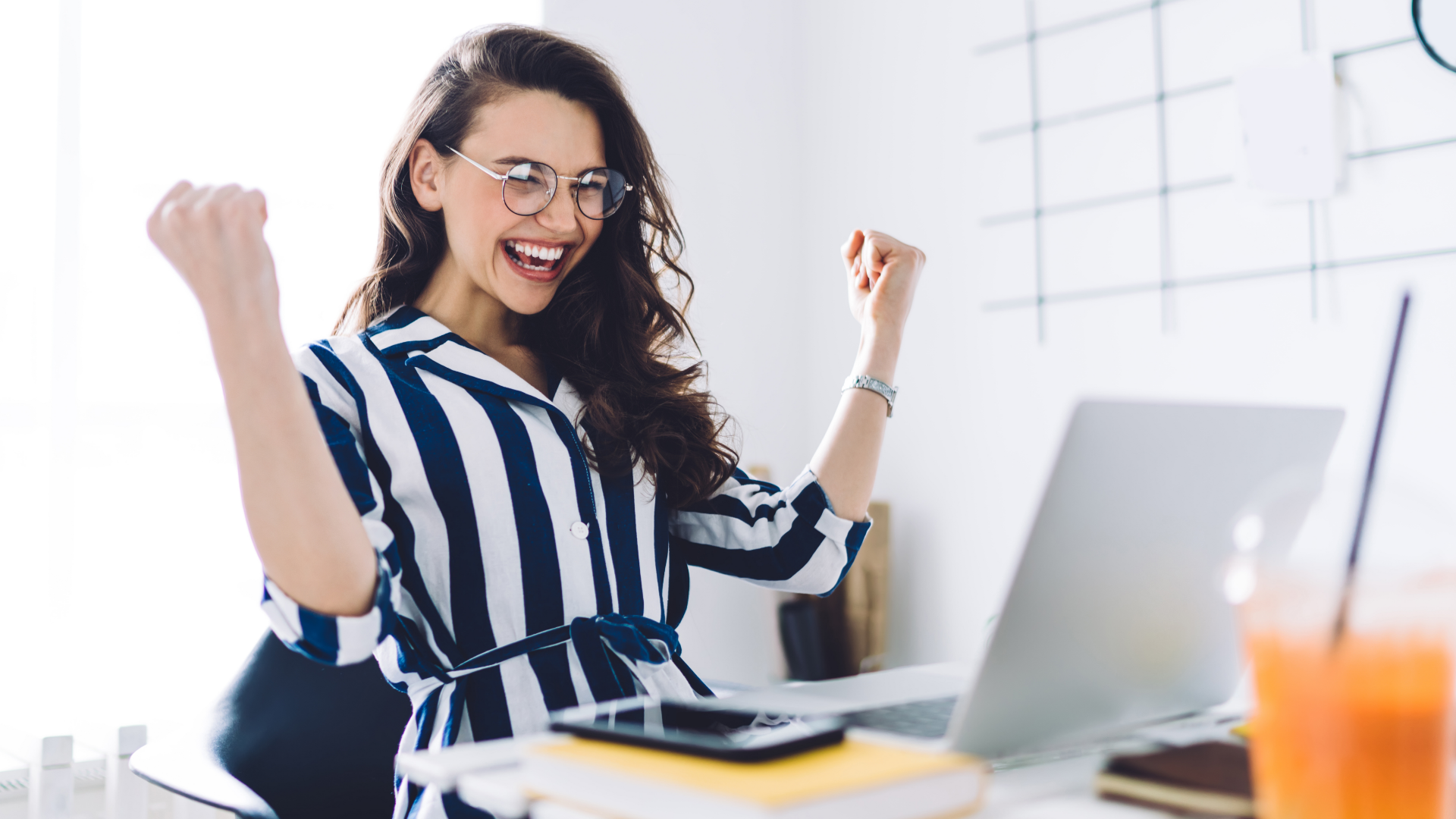 A life insurance agent working from home and celebrating in front of her computer