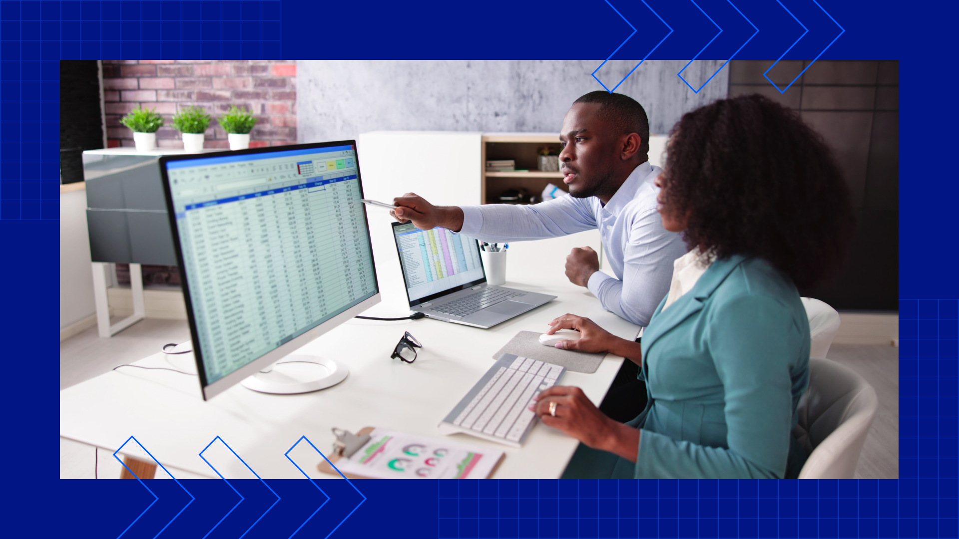 Two life insurance agents looking at a screen full of metrics while sitting at a desk